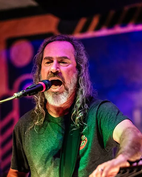 Bean singing and playing bass on stage